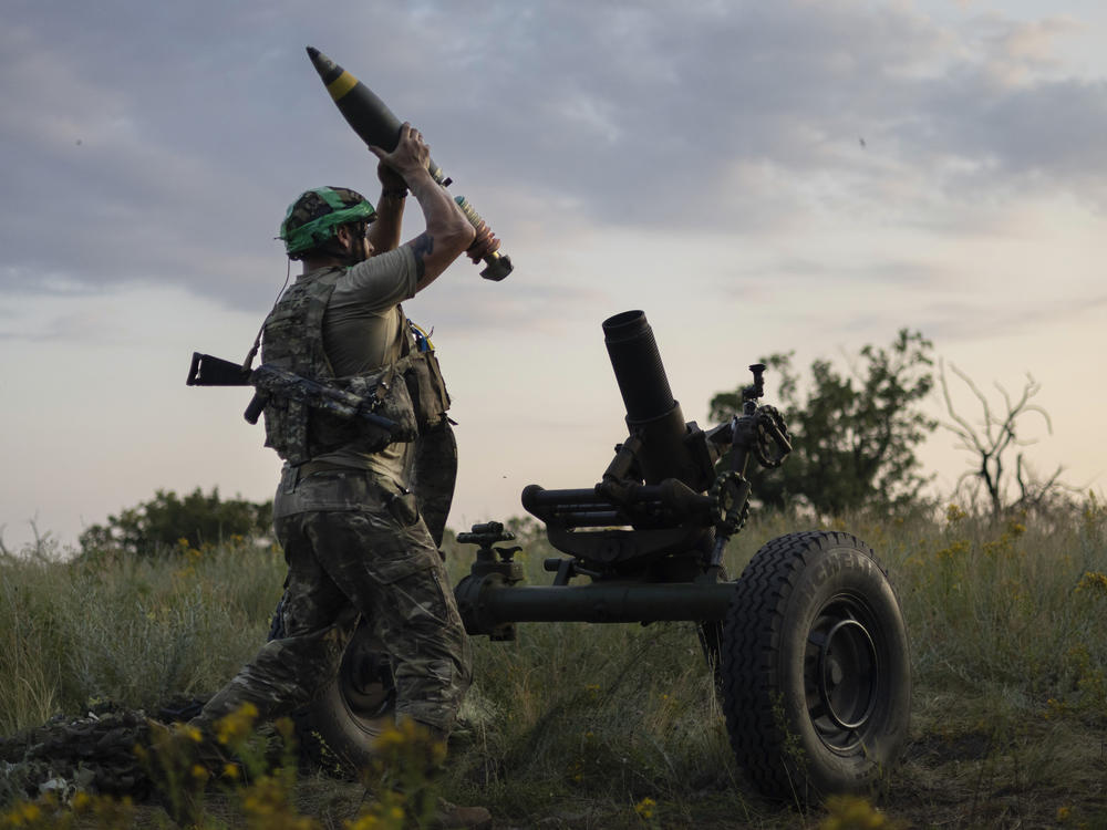 A Ukrainian serviceman of the 3rd Assault Brigade prepares to fire a mortar toward Russian positions near Bakhmut, Donetsk region, Ukraine, Sunday.