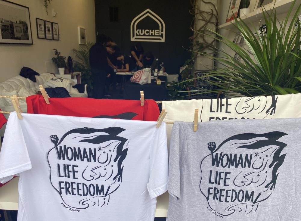 The slogan of the women's revolution on shirts hanging in Kucheh Art Studio + Shop in Washington, D.C.