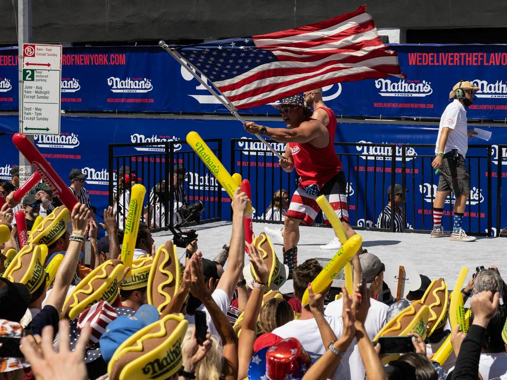 A performer waves an American flag during the 2022 Nathan's Famous Fourth of July hot dog eating contest.