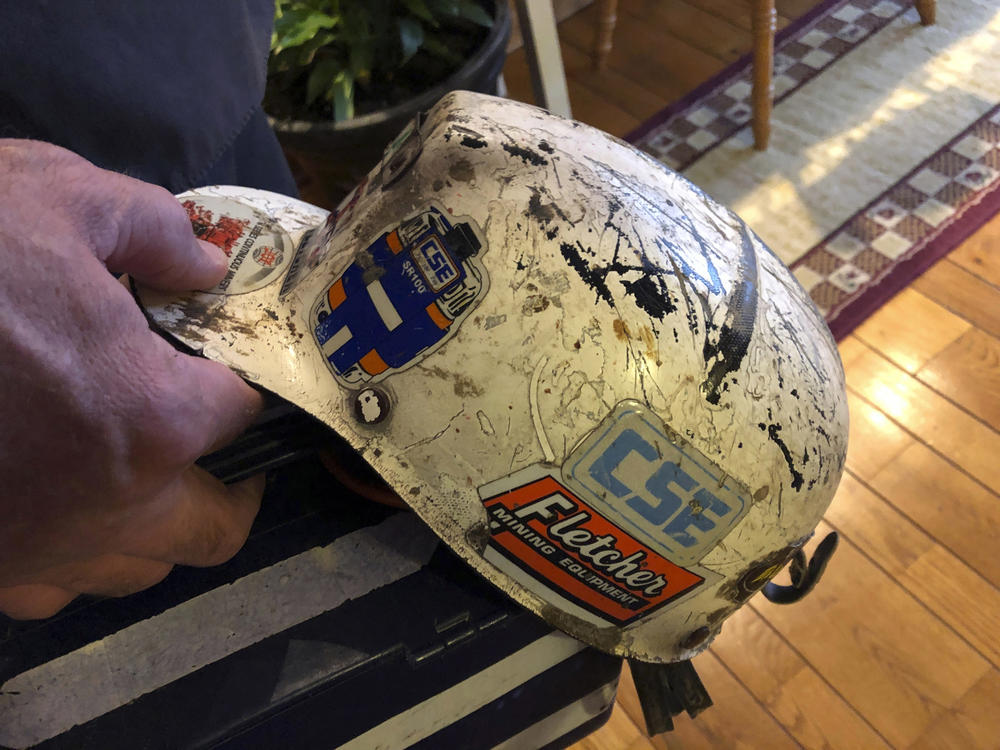 Retired coal miner John Robinson, who suffers from black lung disease, displays his mining helmet at his home in Coeburn, Va., in 2019.