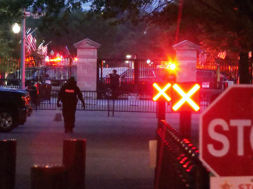 Police are seen outside the White House grounds, Sunday night, July 2, 2023 in Washington.