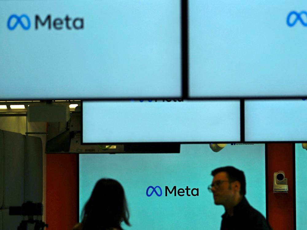 Visitors stand near screens displaying the Meta logo in Berlin on June 6. Under a U.S. judge's new ruling, much of the federal government is now barred from working with social media companies to address removing content that might contain 