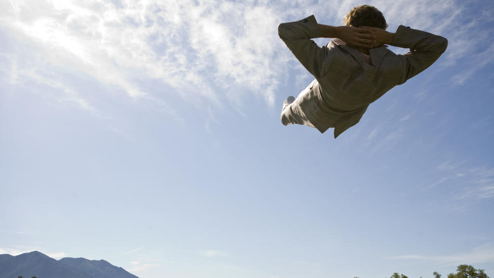 A young male in a retro suit looks relaxed as he floats above the Montana countryside.