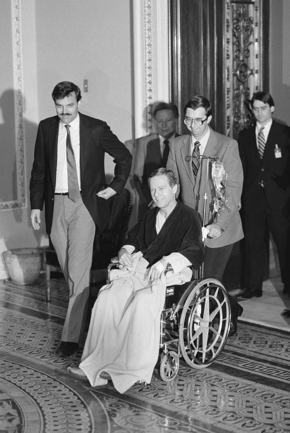 Sen. Pete Wilson, R-Calif., is wheeled out of the Senate Chamber after casting his vote on the 1986 budget in Washington on May 10, 1985. Wilson who underwent surgery for a ruptured appendix on Wednesday was summoned from Bethesda Naval Hospital and was brought to the Capitol by ambulance.