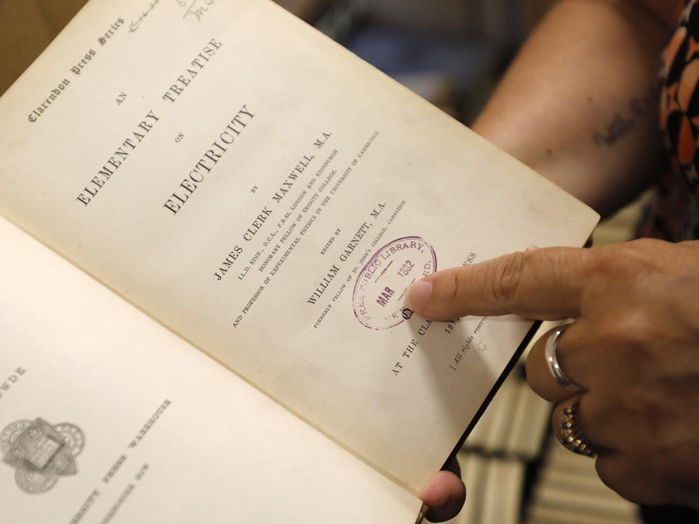 New Bedford Public Library Director Olivia Melo on Friday points to a stamp dating to 1882 when the New Bedford library system acquired the book.