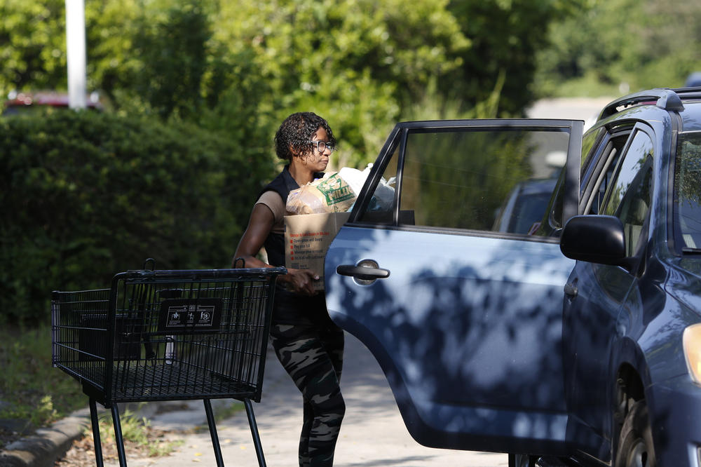 Food bank employee LeAnna Gibson loads a car.