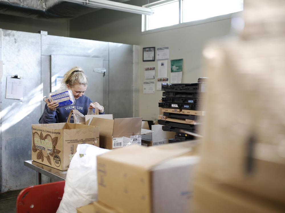 Volunteer Ella Cagle of Wake Forest loads bags with frozen meat. The food bank serves individuals and families in need with a week's worth of groceries.