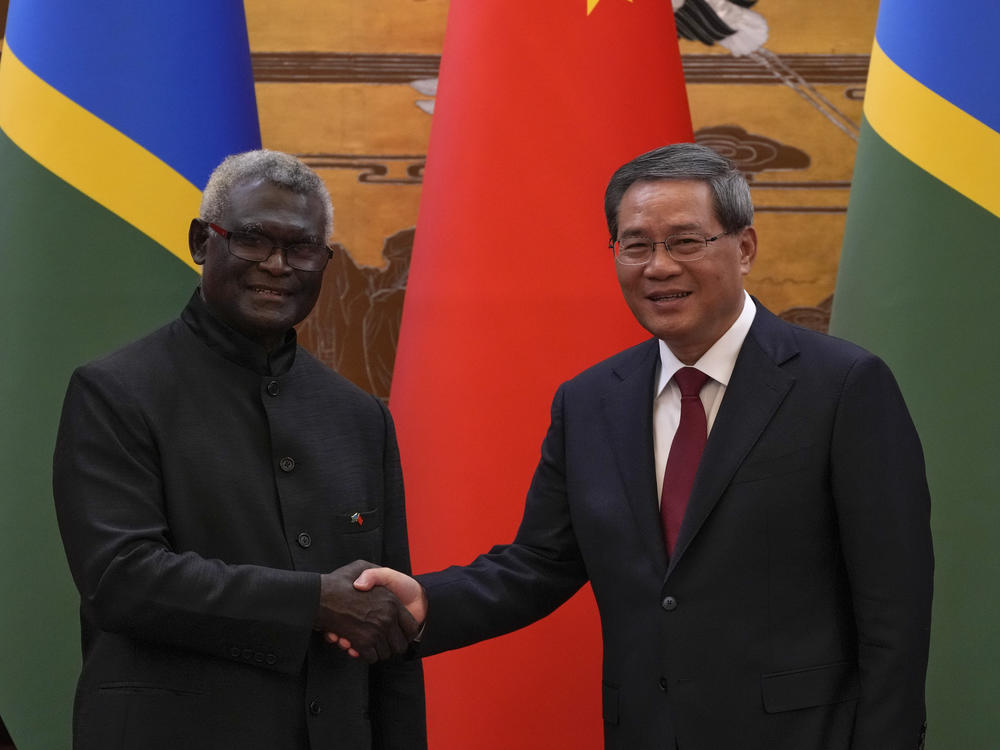 Visiting Solomon Islands Prime Minister Manasseh Sogavare, left, shakes hands with his Chinese counterpart Li Qiang after they witnessed signing on agreement for both countries at the Great Hall of the People in Beijing, Monday, July 10, 2023.