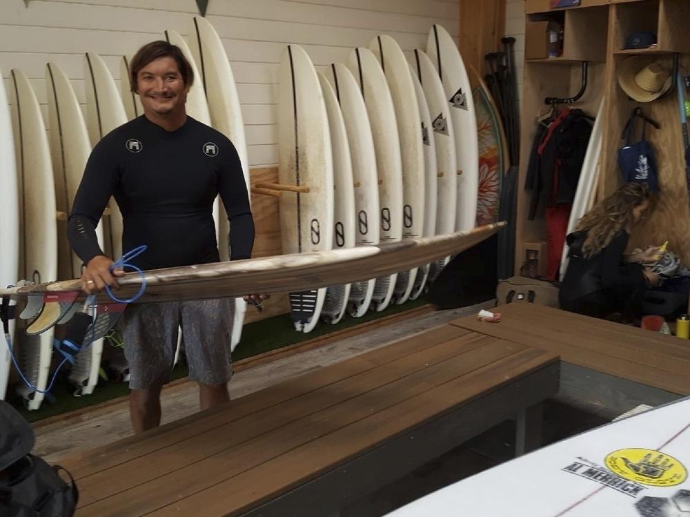 This May 19, 2019, photo provided by Dr. John Jones shows Mikala Jones at Surf Ranch in Lemoore, Calif., holding a surfboard his brother Daniel Jones made using material from the agave plant.