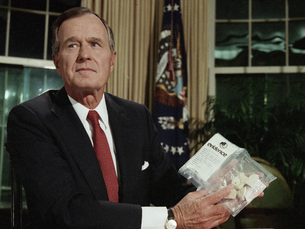 President George H. W. Bush holds a bag of crack cocaine as he poses for photographers in the Oval Office of the White House, Sept. 5, 1989.