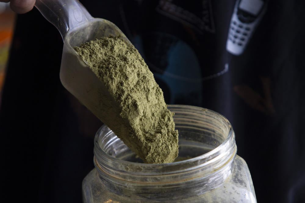 A vendor weighs green vein kratom to sell by the gram at a vape shop in Lake Worth, Fla. Kratom is derived from the dried leaves of a tree in the coffee family. It's been used as traditional medicine in Southeast Asia for centuries.