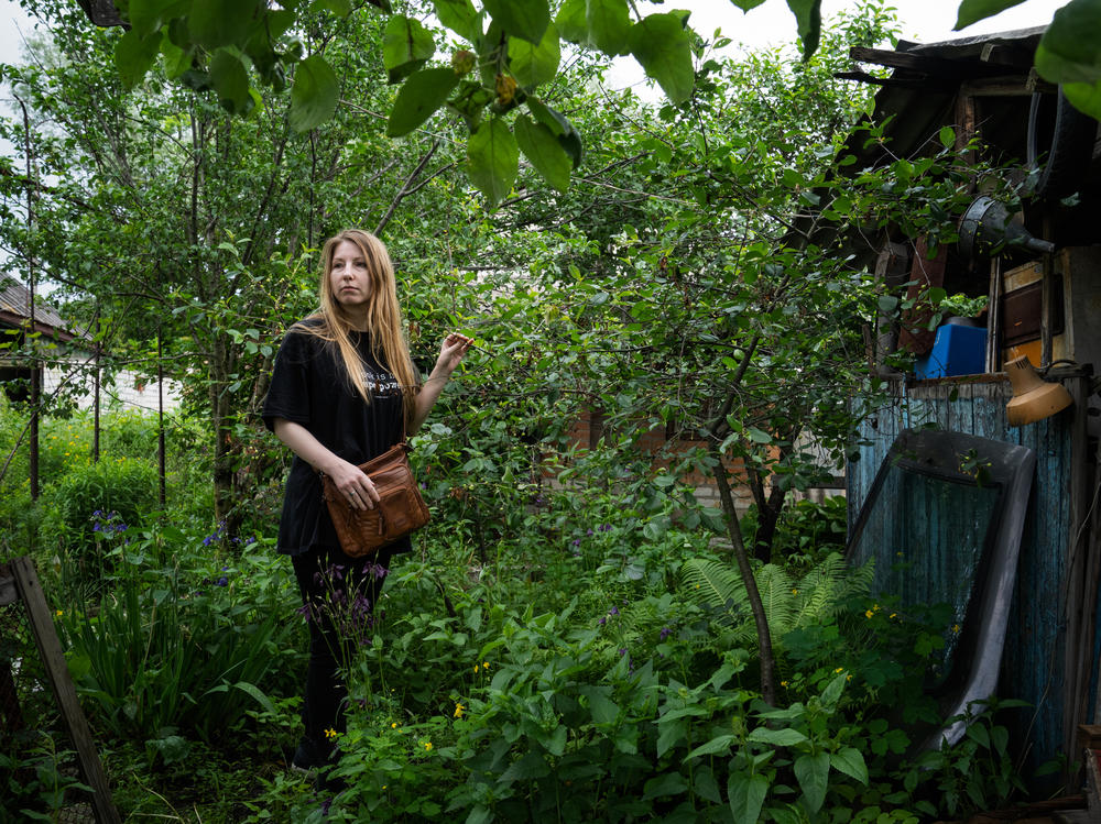 Victoria Amelina stands next to a cherry tree in the backyard of Volodymyr Vakulenko, a Ukrainian children's book author, where he buried his diary of living under Russian occupation in Kapytolivka before he was killed.
