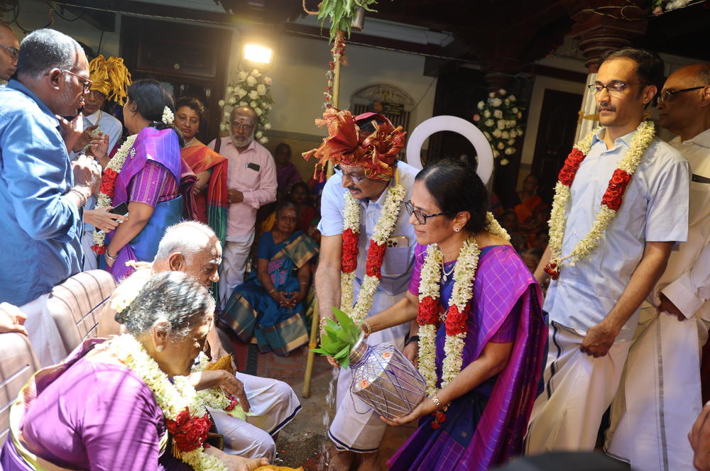 My parents pour holy water over my grandparents — a ritual that is part of the vow renewal ceremony.