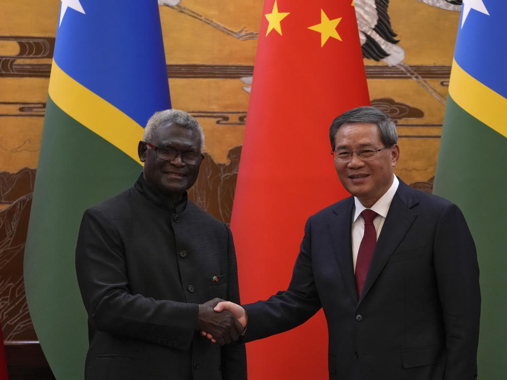 Visiting Solomon Islands Prime Minister Manasseh Sogavare, left, shakes hands with his Chinese counterpart Li Qiang after they witnessed signing on agreement for both countries at the Great Hall of the People in Beijing, Monday, July 10, 2023.