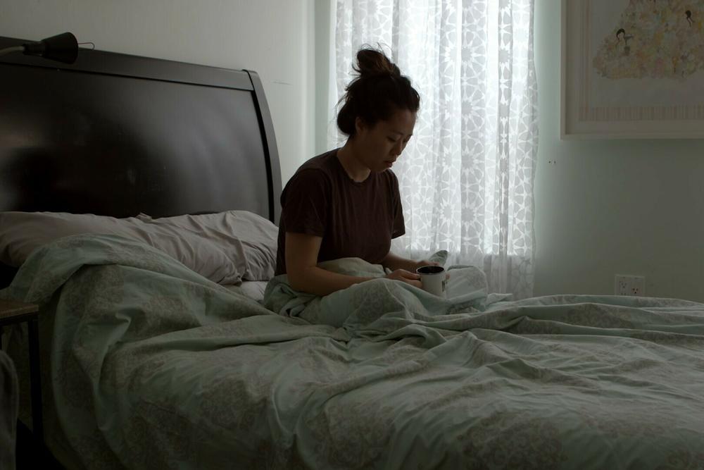 In this still from <em>Below the Belt,</em> Kyung Jeon-Miranda, a Brooklyn-based artist, has a reflective moment. She is still trying to get pregnant despite the impact of endometriosis on her fertility.