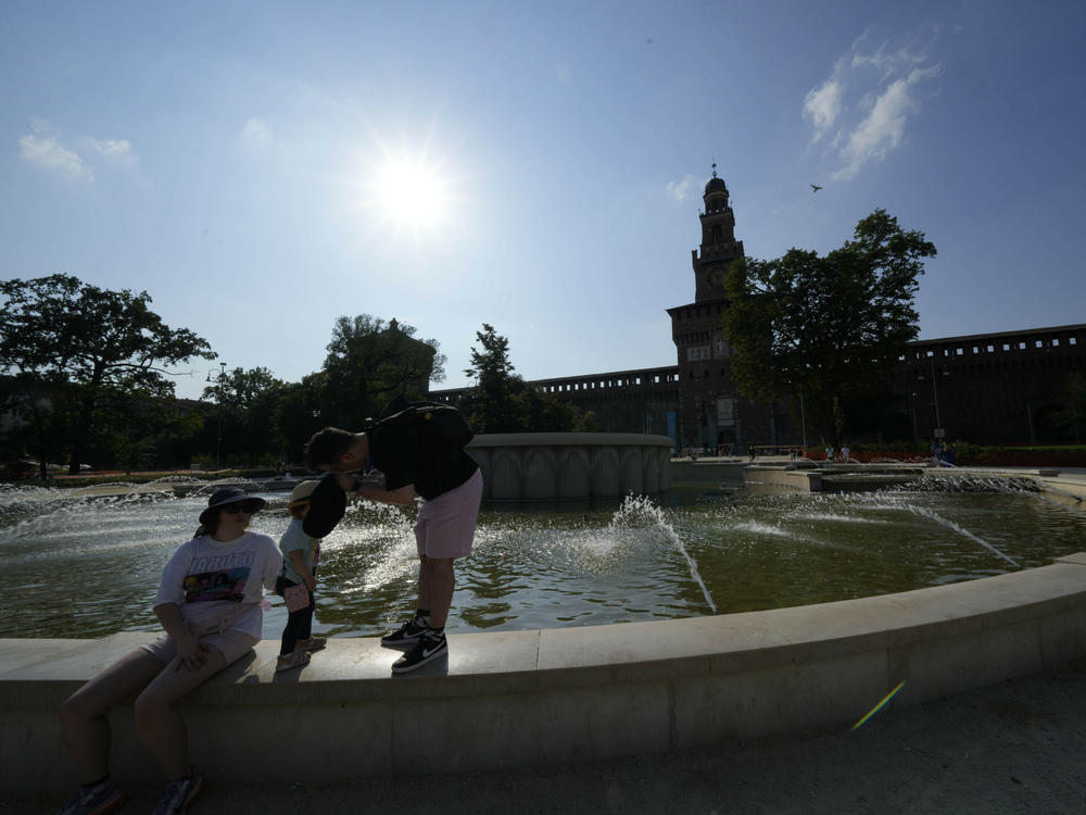 Tourists cool off in a public fountain at the Sforzesco Castle, in Milan, Italy, on Saturday. Temperatures reached up to 42 degrees Celsius in some parts of the country, amid a heat wave that continues to grip southern Europe.