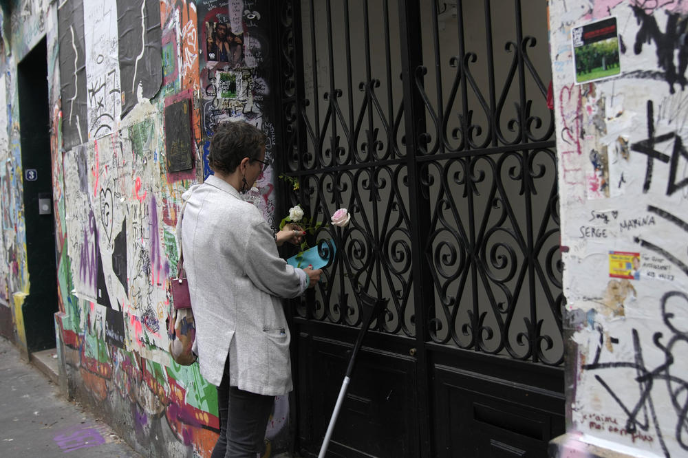 A person places flowers at the house where Jane Birkin and Serge Gainsbourg lived, on Sunday, in Paris.