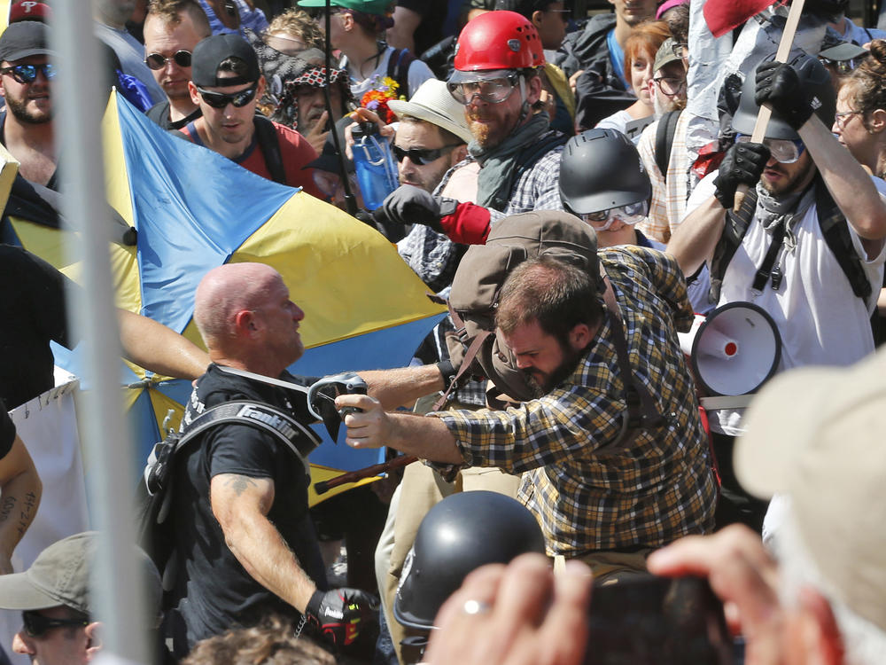 In this Aug. 12, 2017 file photo, white nationalist demonstrators clash with counter demonstrators at the entrance to Lee Park in Charlottesville, Va.