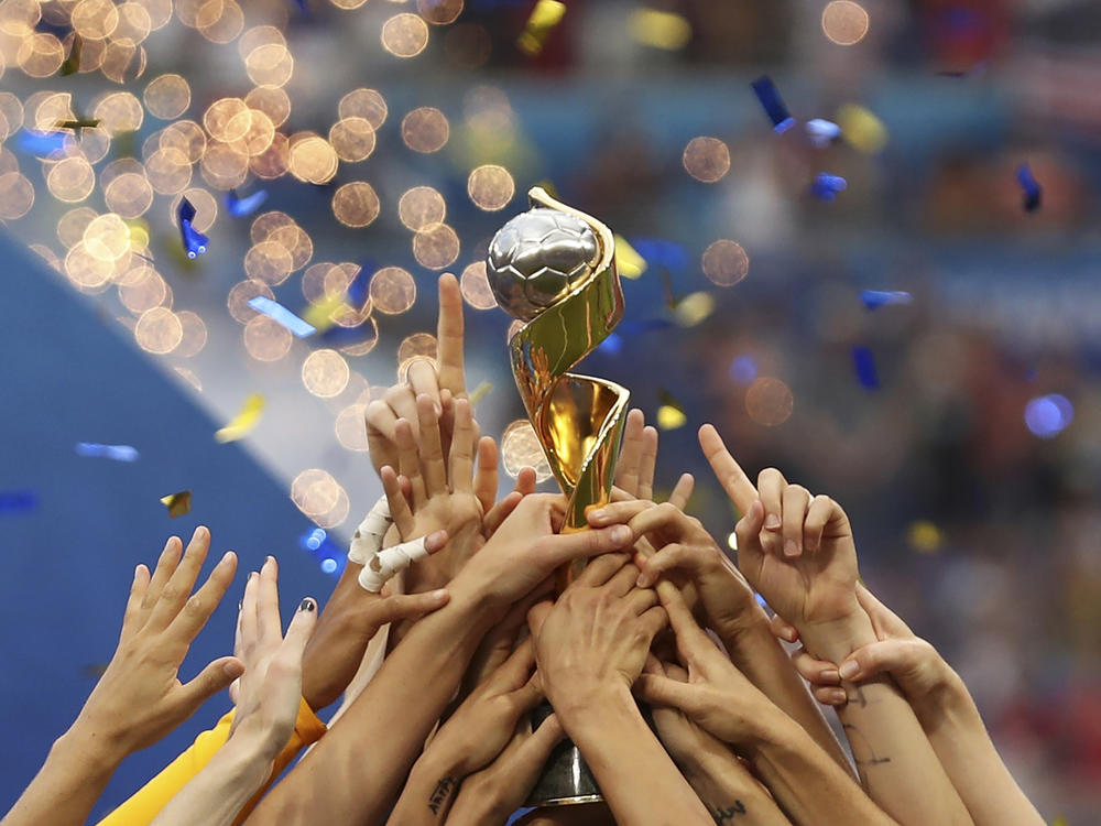 In this photo from July 7, 2019, U.S. players hold the trophy as they celebrate winning the Women's World Cup final soccer match against The Netherlands at the Stade de Lyon in Decines, outside Lyon, France. The 2023 Women's World Cup will be spread across nine cities in Australia and New Zealand.