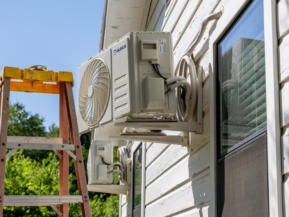 An air conditioner undergoes repair earlier this month in Austin, Texas. Record-breaking temperatures continue across large swaths of the U.S.