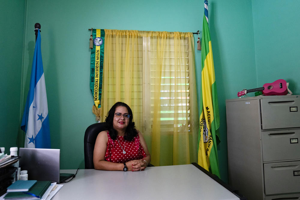 Jacqueline Trejo, mayor of Macuelizo, at her office in city hall, surrounded by her mayoral sash, the Honduran flag and the town flag. She has lots of projects she'd like to launch — including gym equipment in public parks to help keep kids away from drugs and crime.