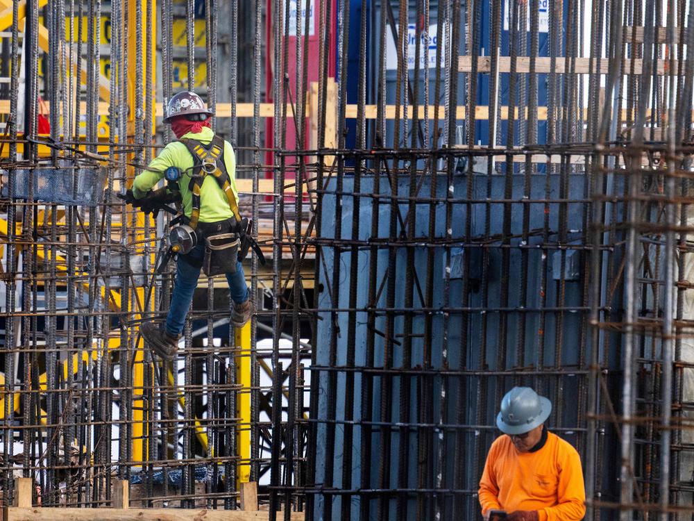 Construction workers erect a building in downtown Miami, on June 14, 2023. The labor market has been surprisingly resilient despite the Fed's aggressive rate hikes, with sectors such as contruction holding up much better than expected.