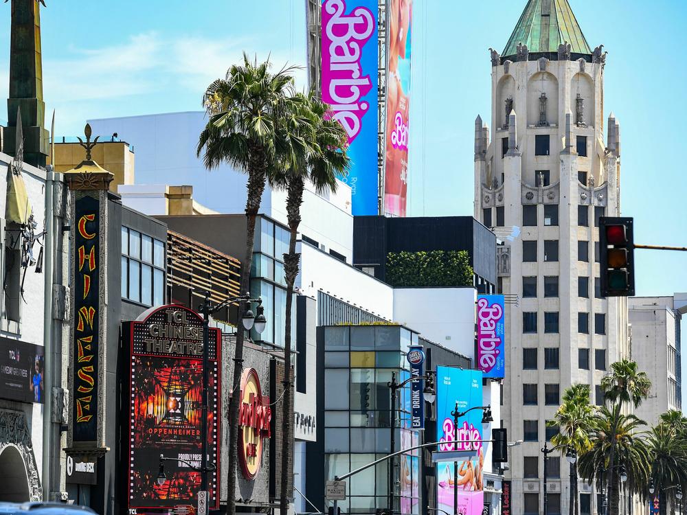 Advertisements for <em>Oppenheimer</em> and <em>Barbie</em> are seen above the Hollywood Walk of Fame on Friday.