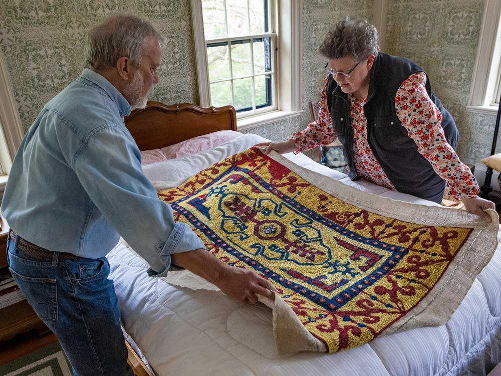 John Shambroom and Loose Ends volunteer Jan Rohwetter examine the rug Shambroom's wife, Donna Savastio, couldn't finish due to symptoms of Alzheimer's.