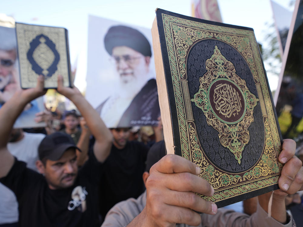 Iraqis raise copies of the Quran, Muslims' holy book, during a protest in Baghdad, Saturday. Hundreds of protesters attempted to storm Baghdad's heavily fortified Green Zone, which houses foreign embassies and the seat of Iraq's government, following reports of the burning of a Quran by a ultranationalist group in front of the Iraqi Embassy in Copenhagen.