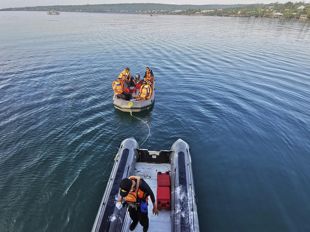 In this photo provided by the National Search and Rescue Agency (BASARNAS), rescuers on a rubber boat search for survivors after an overloaded ferry sank off Sulawesi Island, Indonesia, Monday, July 24, 2023.