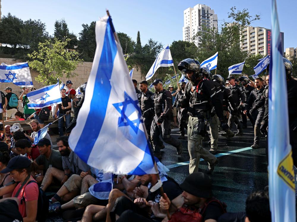 Israeli security forces remove protesters blocking the entrance of the Knesset, Israel's parliament, in Jerusalem on Monday.