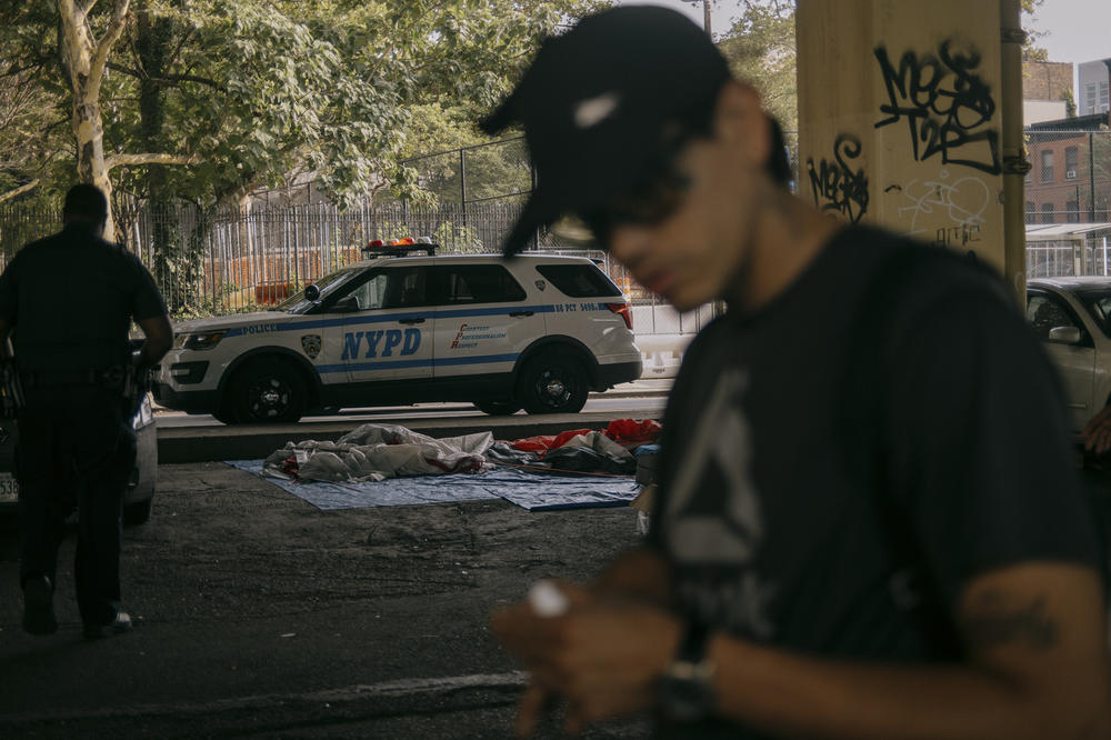 NYPD officers briefly stop by the campsite to notify residents that they will be returning in the coming days with members of a non-profit that intends to help find them adequate shelter. Brooklyn, New York, U.S., on Wednesday, July 19, 2023.
