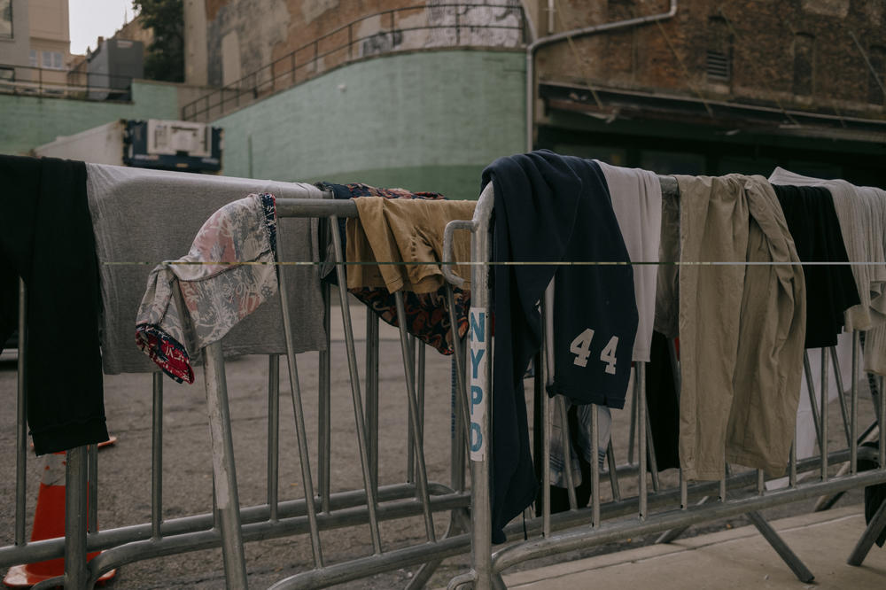 Clothing — washed inside the facility's two shower units — hangs to dry. Brooklyn, New York, U.S., on Wednesday, July 19, 2023.