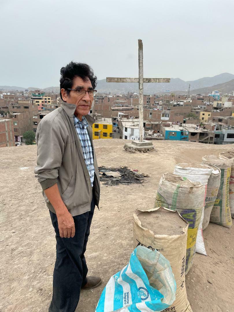 Benito Trejo, president of the local neighborhood association, at the top of Infantas 1 pyramid next to bags of sand that people have been digging up, possibly to sell to construction companies.