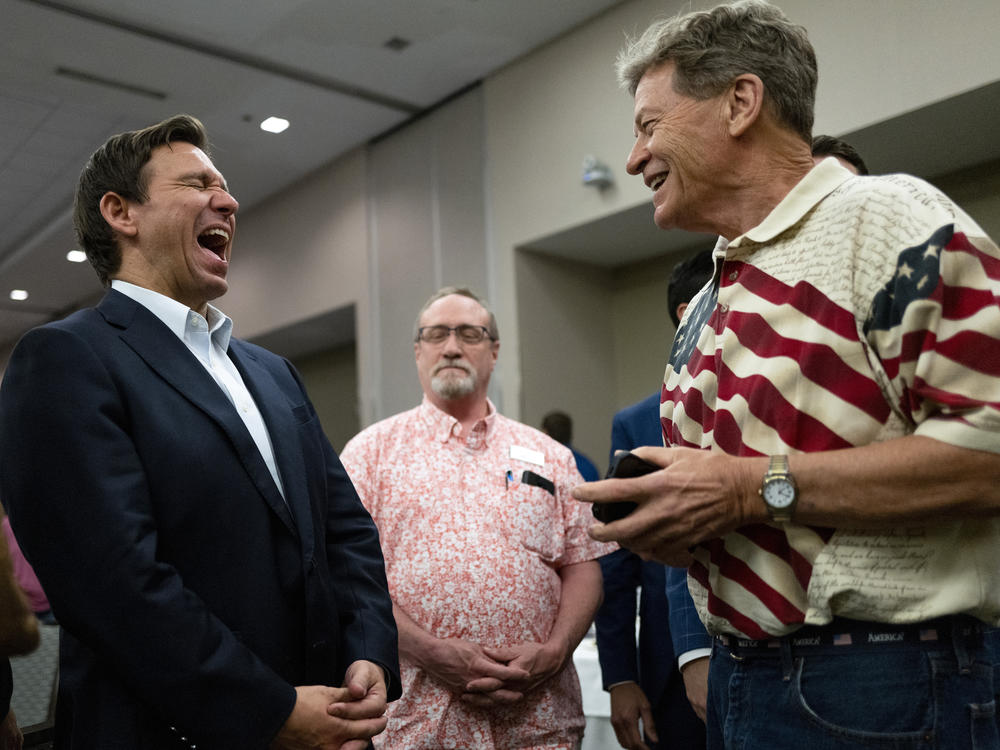 Florida Gov. Ron DeSantis (L) speaks with attendees during an Iowa GOP reception on May 13, 2023 in Cedar Rapids, Iowa.