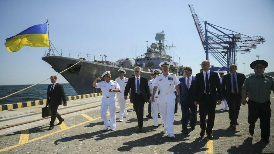 In this 2015 photo, U.S. Adm. James Foggo (center, in white uniform), meets Ukrainian leaders during training exercises between NATO and Ukraine in the port city of Odesa. The frigate in the background was the flagship of Ukraine's Black Sea fleet. But Ukraine chose to scuttle the warship last year, rather than risk it being captured by Russia when Moscow launched a full-scale invasion.