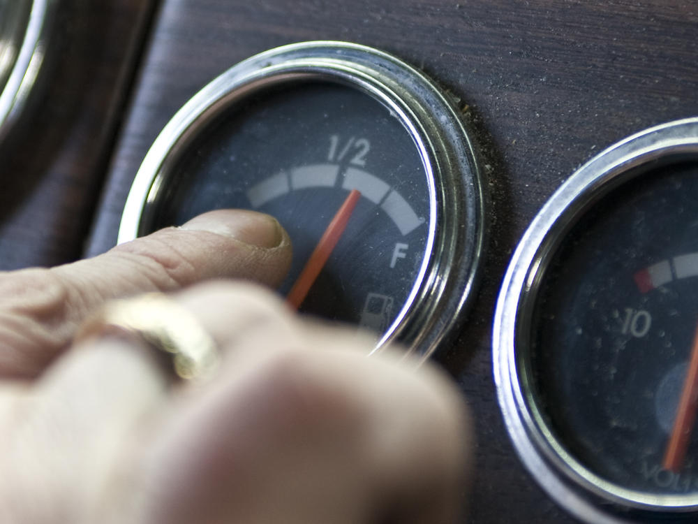 A truck driver points to his fuel gauge in 2008. The Biden administration is now proposing to increase the fuel efficiency of cars and trucks.