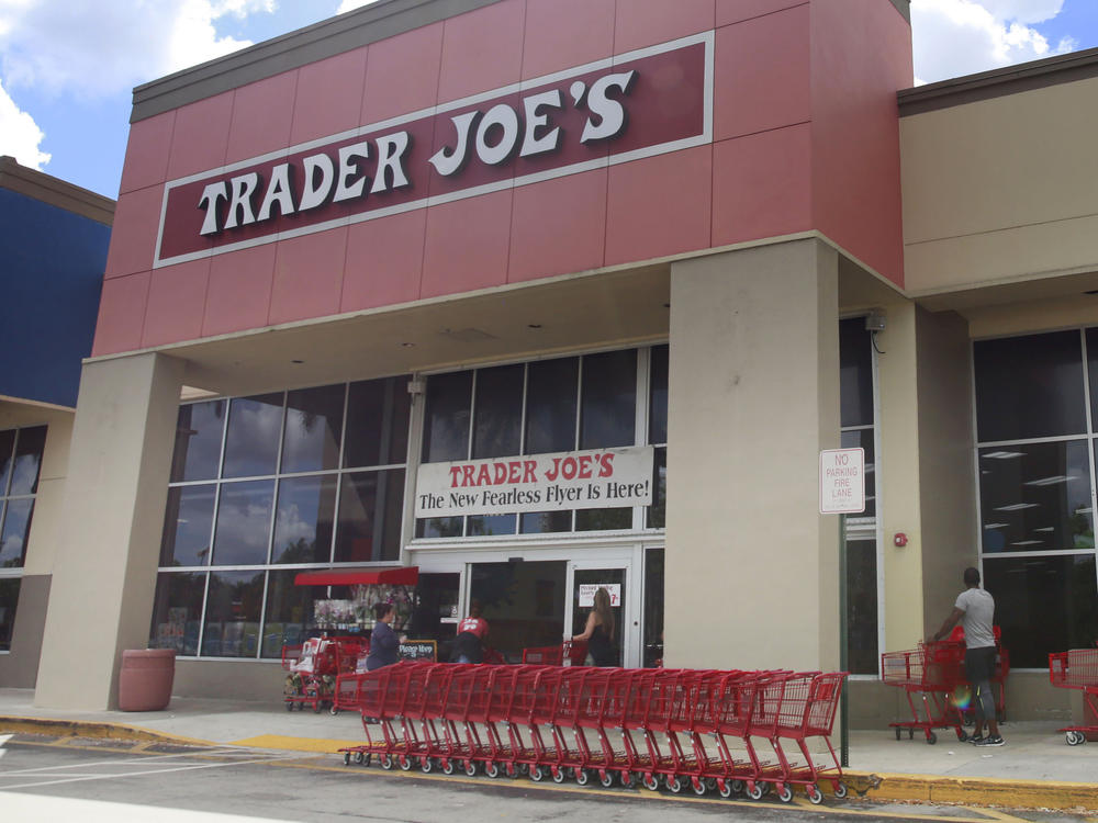 People stand in line waiting to enter Trader Joe's to buy groceries in Pembroke Pines, Fla., on March 24, 2020.