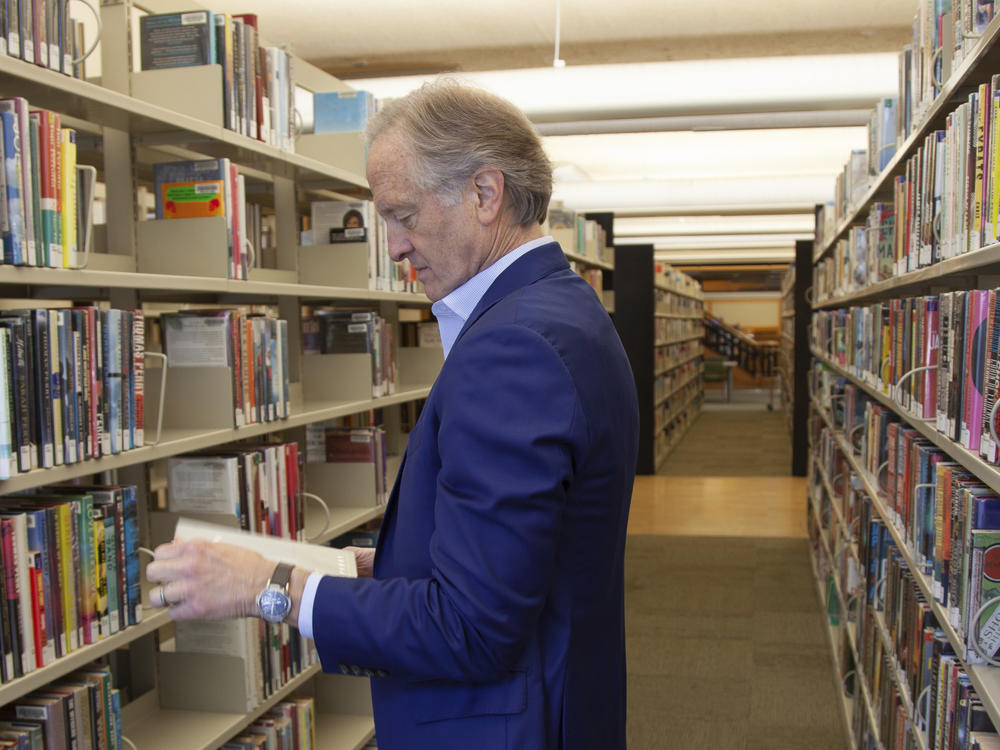 Nate Coulter, executive director of the Central Arkansas Library System (CALS), looks at a book in the main branch of the public library in downtown Little Rock, Ark., on May 23, 2023. Arkansas is temporarily blocked from enforcing a law that would have allowed criminal charges against librarians and booksellers for providing 