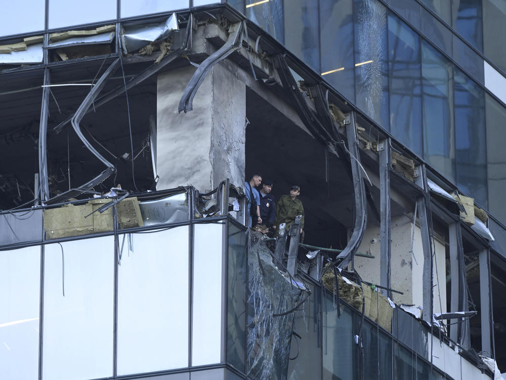 Investigators examine a damaged skyscraper in the 