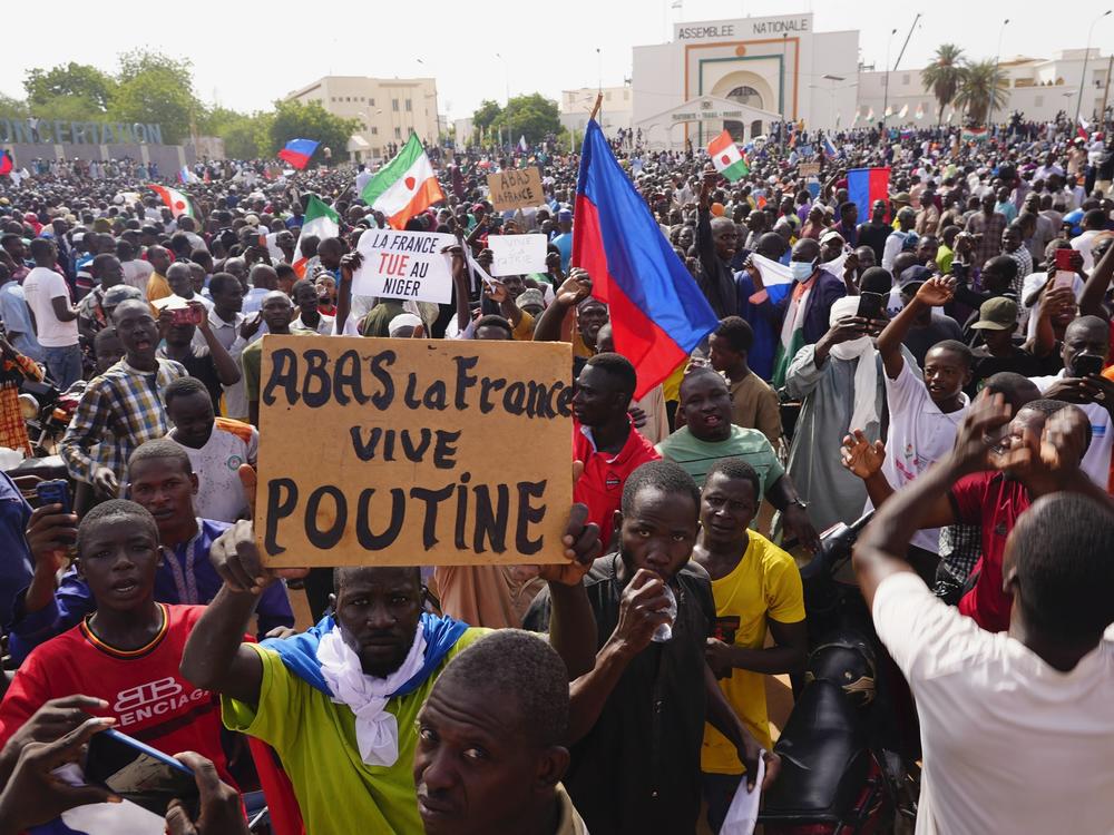 Nigeriens participate in a march called by supporters of coup leader Gen. Abdourahmane Tchiani in Niamey, Niger, Sunday, July 30, 2023. Days after mutinous soldiers ousted Niger's democratically elected president, uncertainty is mounting about the country's future and some are calling out the junta's reasons for seizing control. The sign reads: 