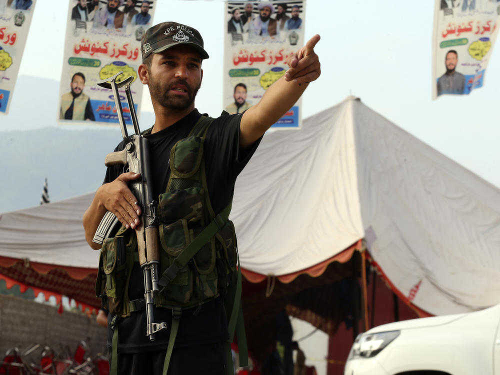 A Pakistani police officer stands guard at the site of Sunday's suicide bomber attack in the Bajur district of Khyber Pakhtunkhwa, Pakistan, Monday, July 31.