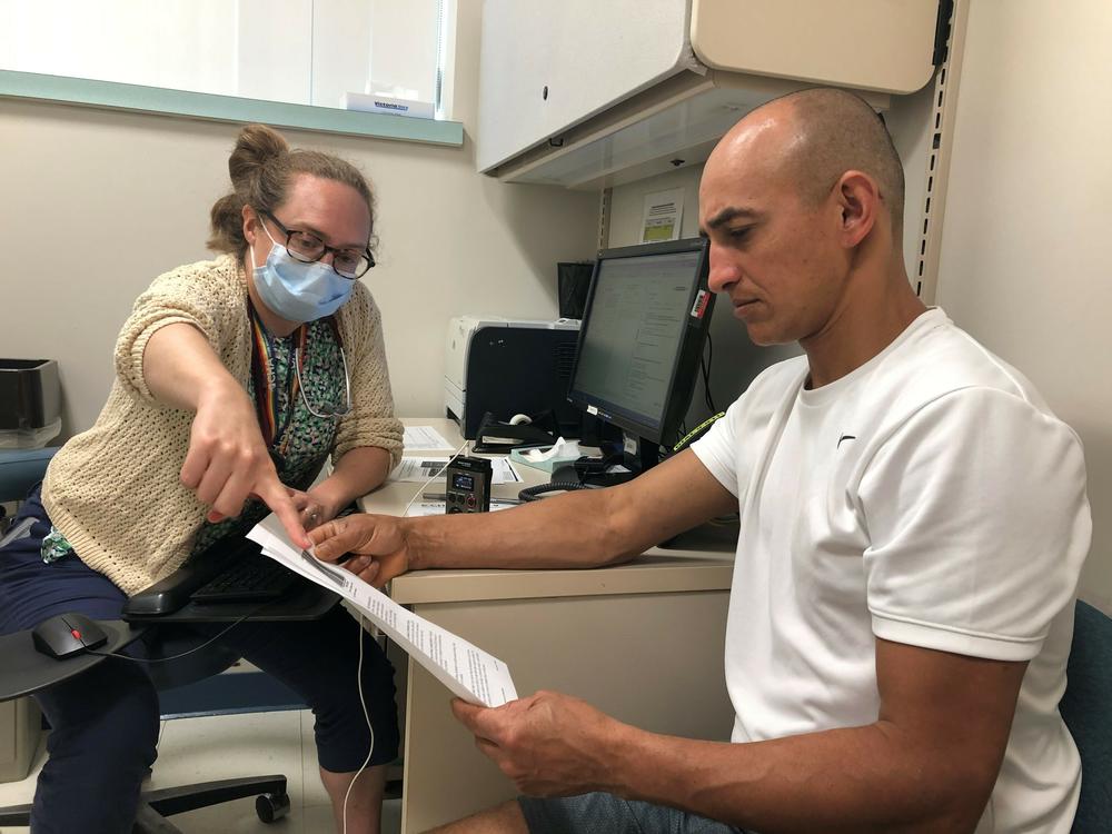 Dr. Rebecca Rogers practices primary care at the Cambridge Health Alliance in Somerville, Mass. During a recent appointment, she went over hydration tips with her patient Luciano Gomes, who works in construction.
