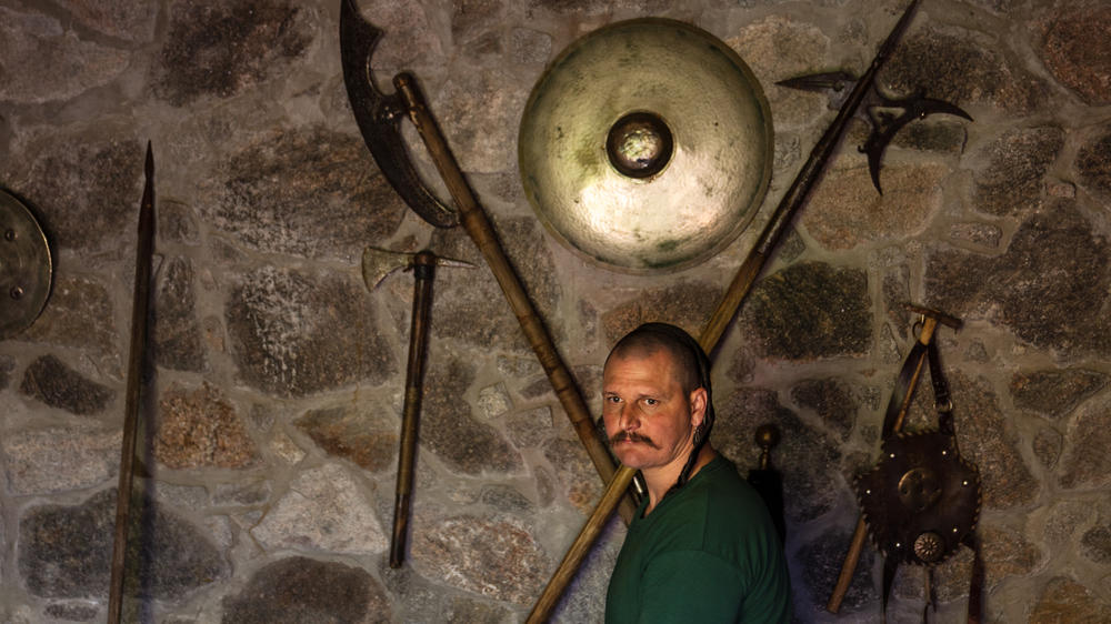 Andrii Lozovyi stands near some traditional Cossack weapons.