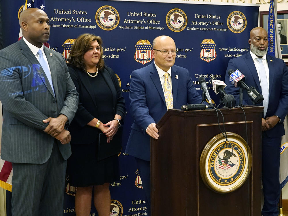U.S. Attorney Darren J. LaMarca, center, speaks to reporters after six white former law enforcement officers in Mississippi pleaded guilty to federal civil rights offenses in federal court in Jackson, Miss., Thursday, Aug. 3, 2023.
