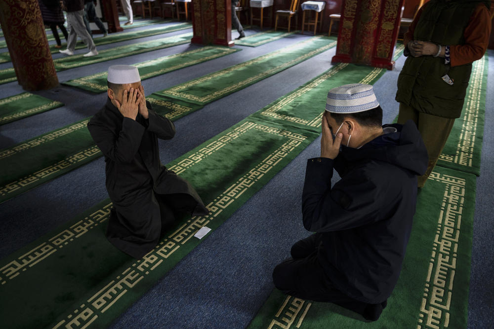 A Chinese Muslim cleric (left) leads a worshipper in a special prayer after Eid al-Fitr prayers at the historic Niujie Mosque on April 22 in Beijing.