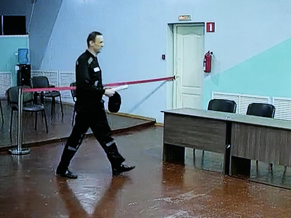 Russian opposition leader Alexei Navalny is seen on a TV screen, as he appears in a video link provided by the Russian Federal Penitentiary Service, during a hearing in the penal colony in Melekhovo, northeast of Moscow, on Friday.