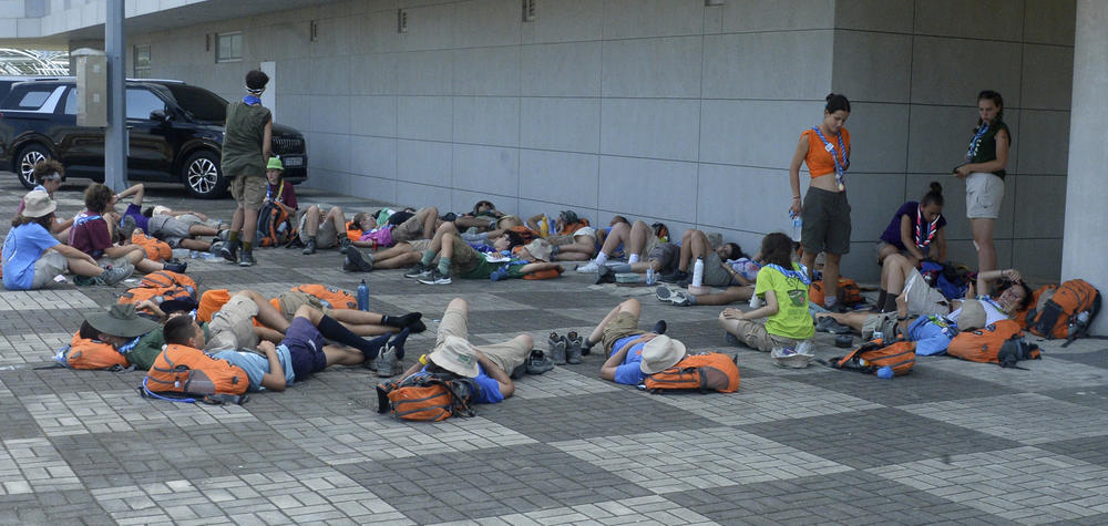 Attendees of the World Scout Jamboree lie down to rest at a scout camping site in Buan, South Korea, on Friday.