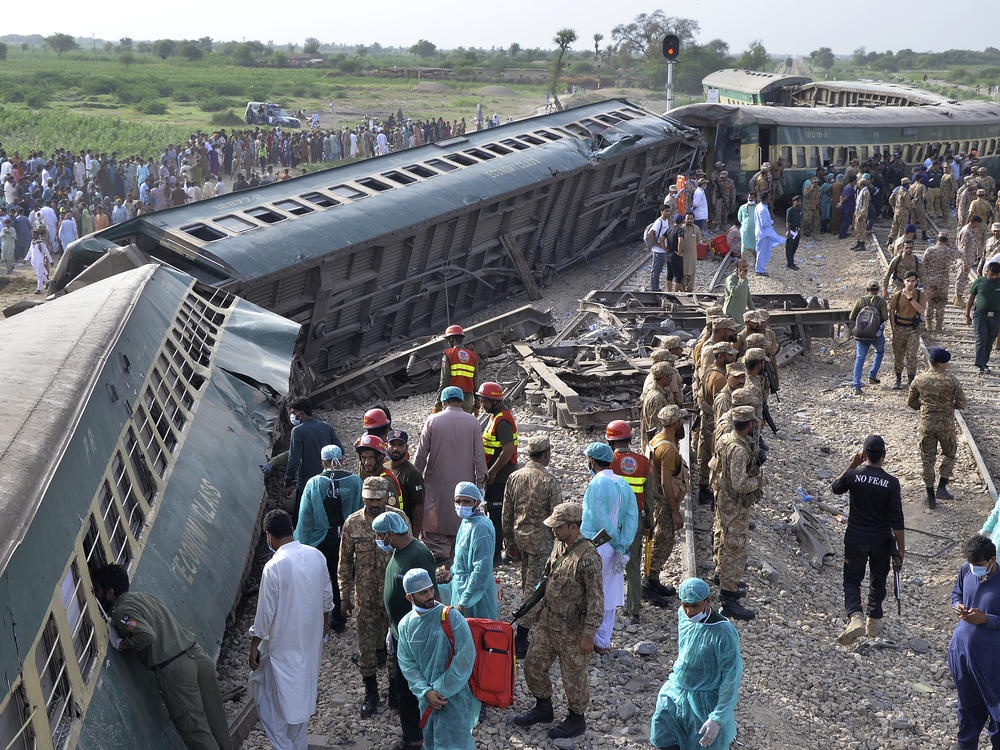 Rescue workers and army troops take in a rescue operation at the site of train derailed outskirts of Sarhari railway station in Nawabshah, Pakistan on Sunday.