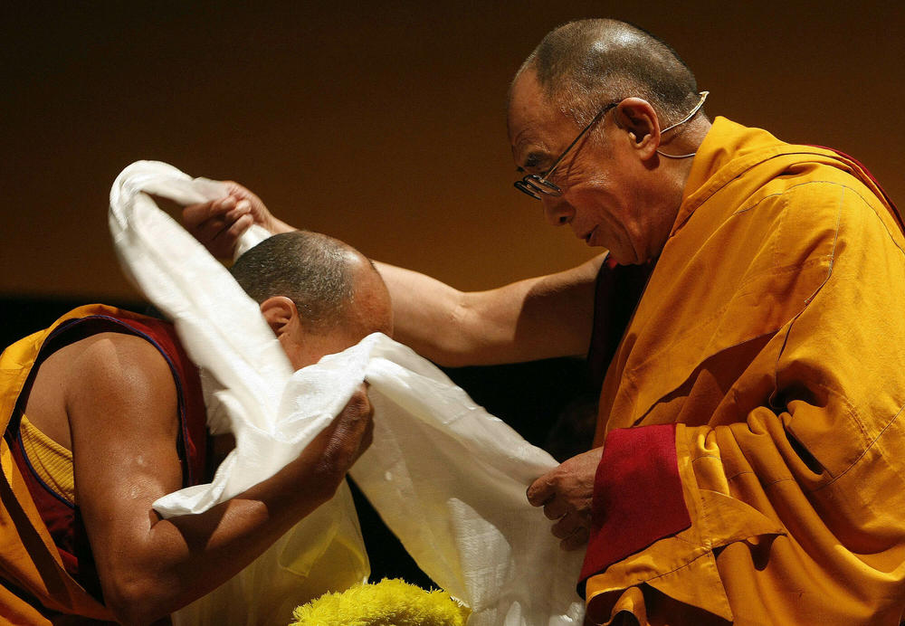 Tibet's spiritual leader the Dalai Lama gives his blessing to a Buddhist monk at the closing ceremony for the 2009 Parliament of the World's Religions in Melbourne, Australia.